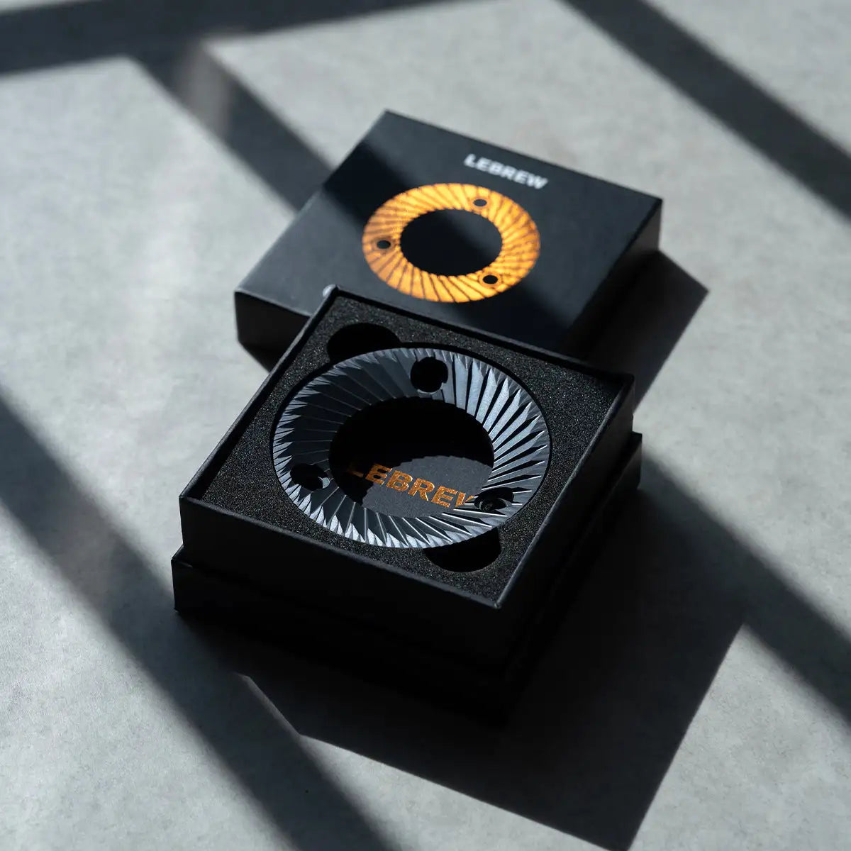 LeBrew Filter Burr in a black box on a gray surface