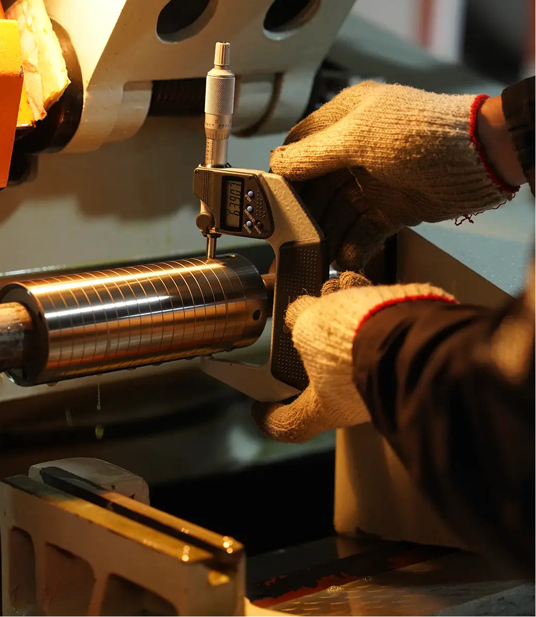 Person wearing gloves operating a machine with a cylindrical component to check Lebrew Burrs precision measurement, and accuracy